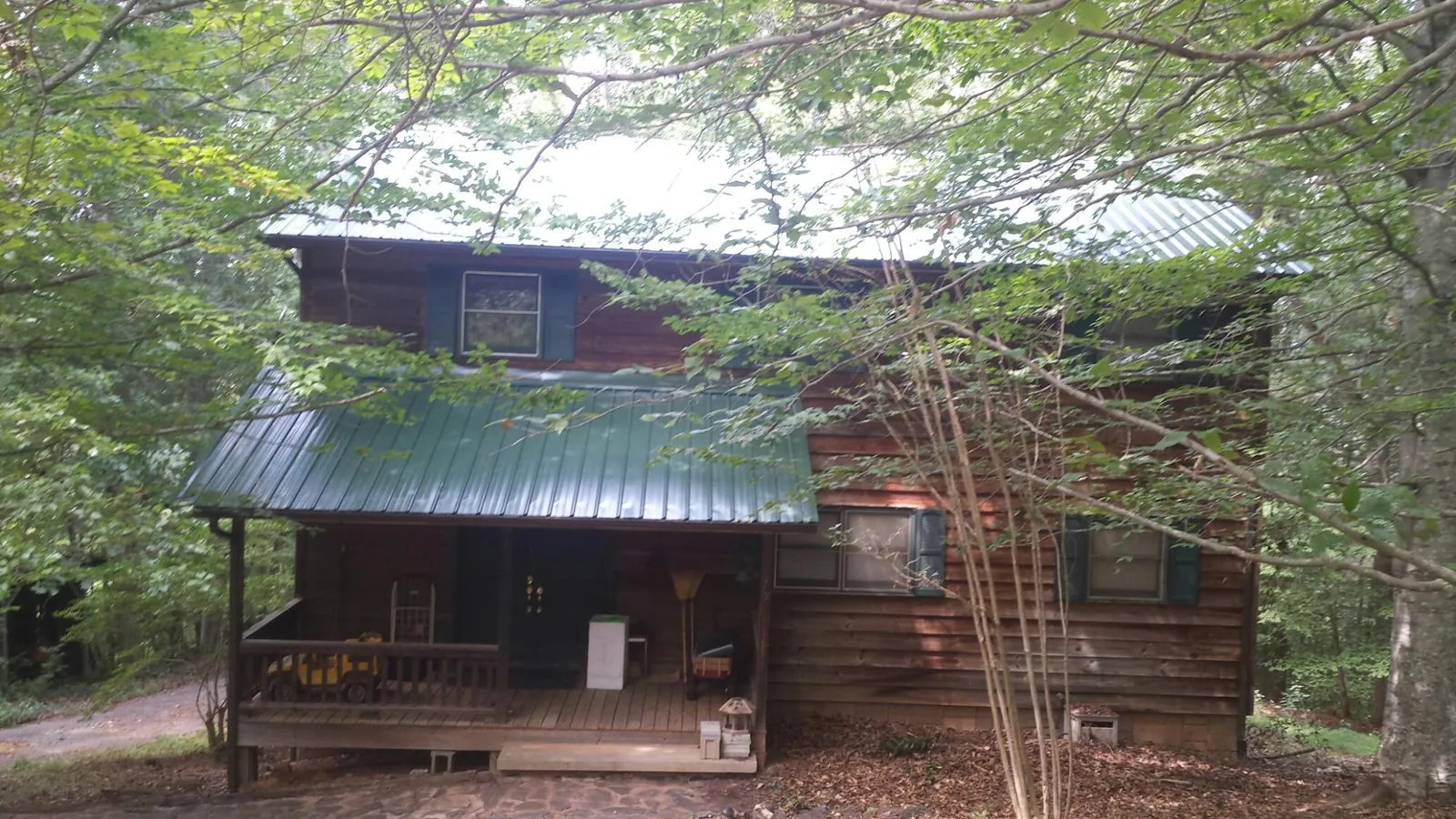 Green metal roof and covered porch on a log cabin in Saltese