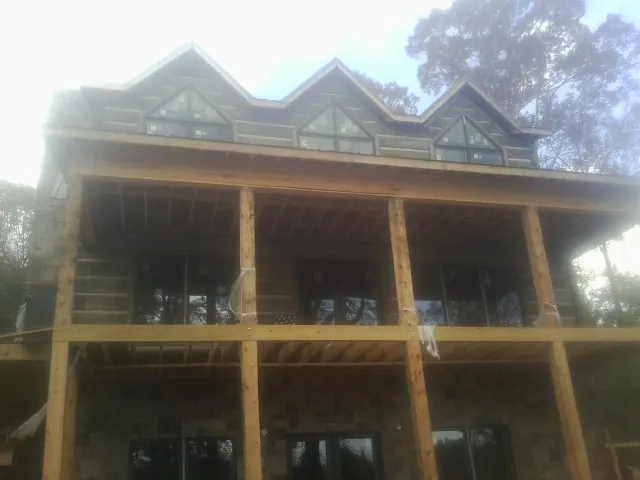 Dormers and porch framing on a large log home under construction — Roof Coating work by our crew in Saltese