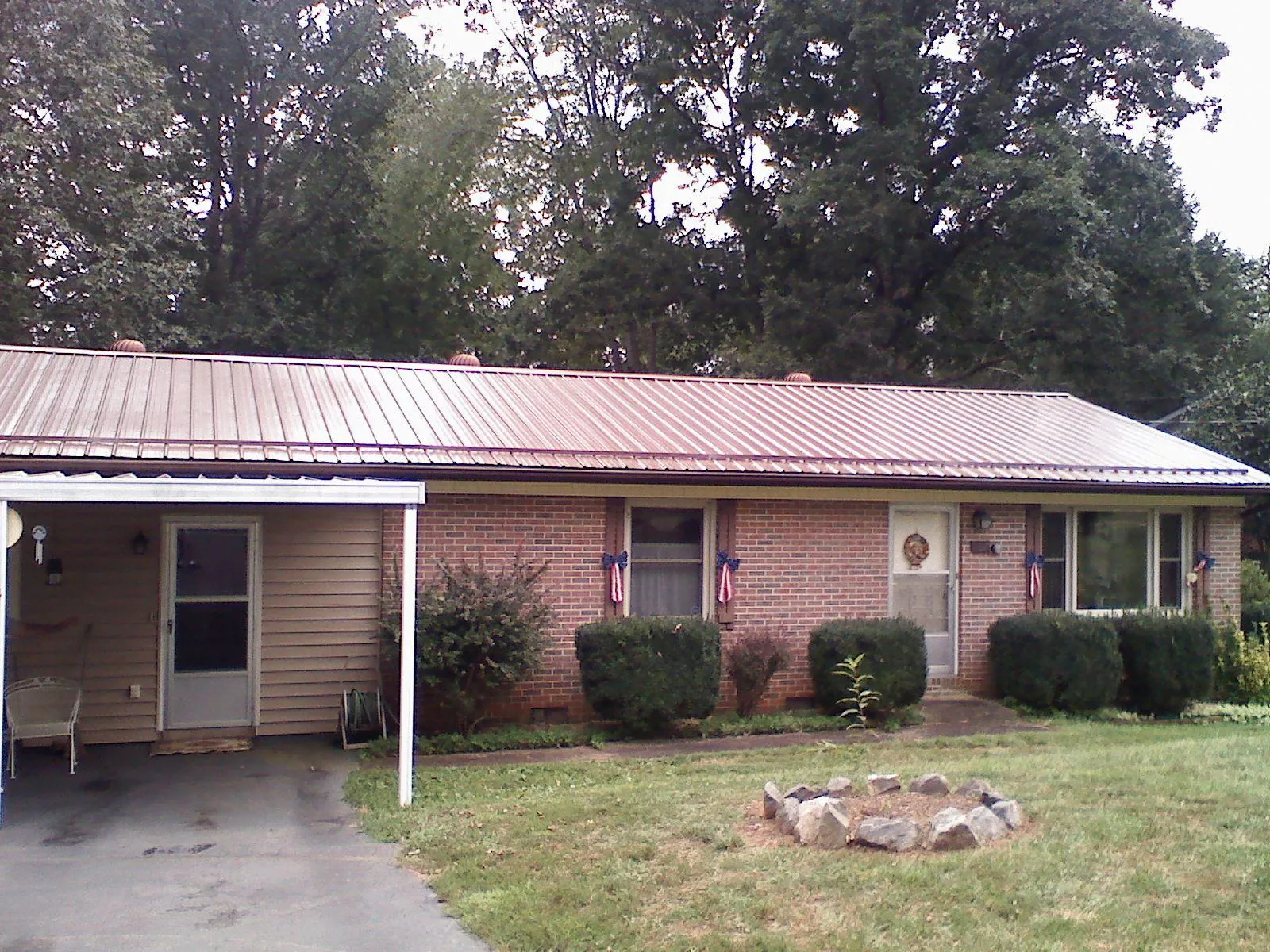 Bronze metal roof and carport on a brick ranch home — Roof Repair work by our crew in Saltese